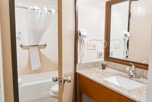 a bathroom with a sink and a mirror and a toilet at The Hills Inn Eagle Rock - Near Old Town Pasadena in Los Angeles