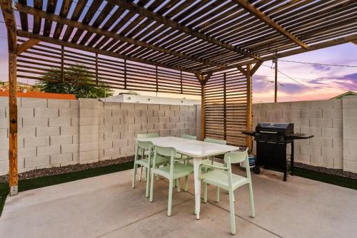 a white table and chairs under a wooden pergola at Spacious home w private pool & game room in Phoenix