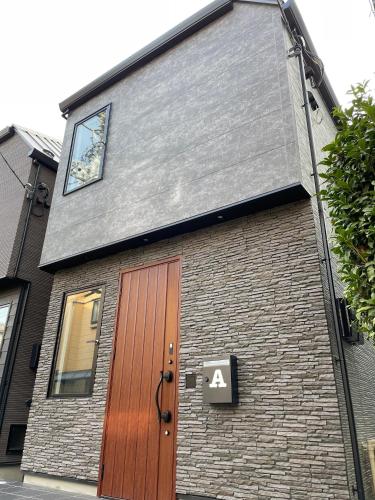 a building with a wooden door and a sign on it at COTO Premium Shibuya A in Tokyo
