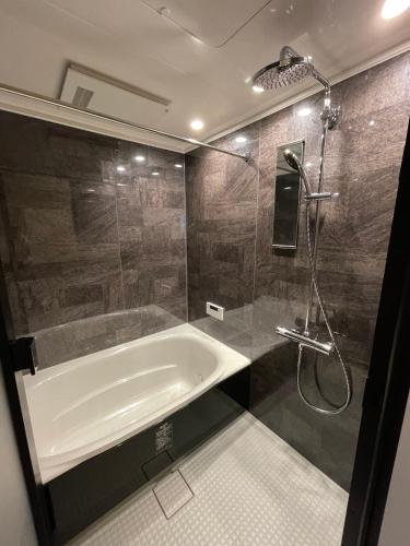 a bathroom with a bath tub and a shower at COTO Premium Shibuya A in Tokyo