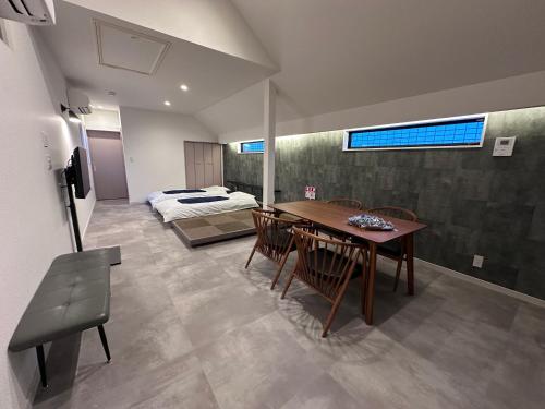 a room with a table and chairs and a bed at COTO Premium Shibuya A in Tokyo