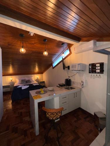 a kitchen with a desk and a bed in a room at Lofts do Pilar - pousada in Ouro Preto