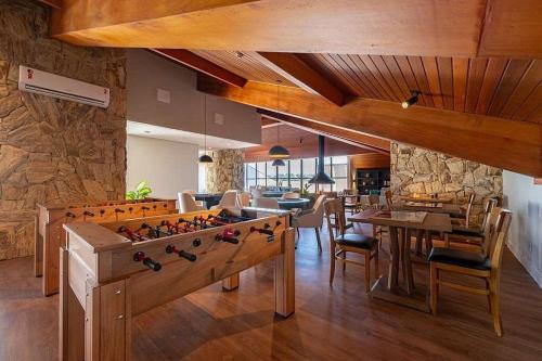 Apartamento sofisticado Campos do Jordão في كامبوس دو جورداو: غرفة معيشة مع طاولة وطاولة بلياردو كبيرة