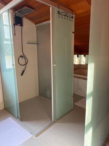 a glass shower door in a room with at Lofts do Pilar - pousada in Ouro Preto