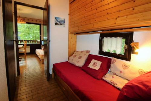 - un salon avec un canapé rouge dans une maison dans l'établissement Résidence Campanule - Les Hauts De Planchamp - Studio pour 3 Personnes MAE-3348, à Champagny-en-Vanoise