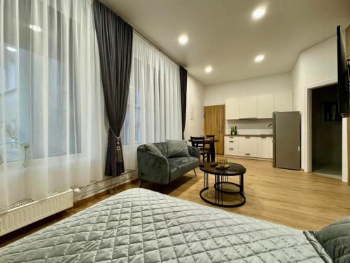 a bedroom with a bed and a table and a kitchen at UAB DU PROCENTAI nt in Šiauliai