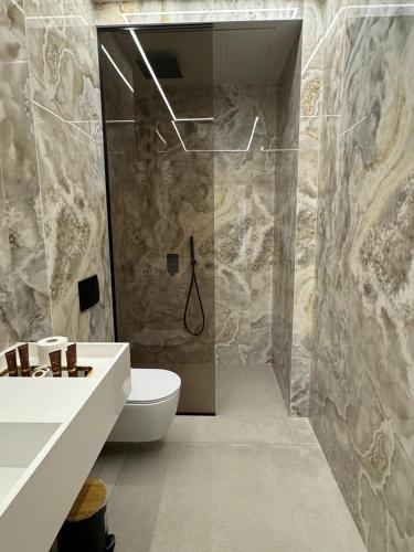 a bathroom with a shower and a toilet and a sink at Hotel Miramare in Vlorë