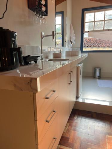 a kitchen with a sink and a counter at Lofts do Pilar - pousada in Ouro Preto