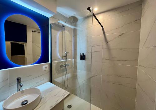 une salle de bain avec un lavabo et une douche avec un miroir dans l'établissement Suite romantique avec Balnéo, à Marseille