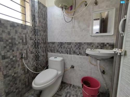 un baño con inodoro y lavabo en Hotel Anugraha, en Kalyānpur