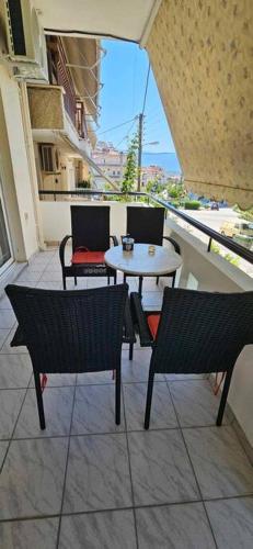 a balcony with a table and chairs on a balcony at Eva's Apartment in Lamía