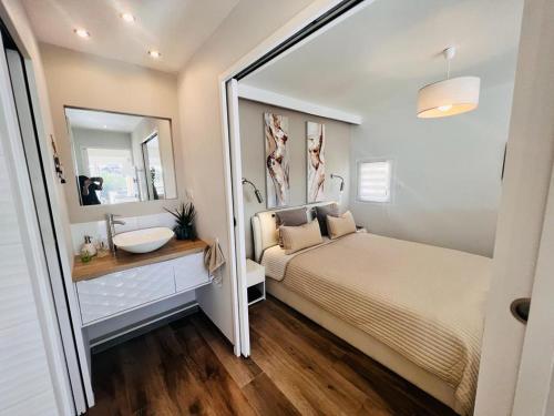 une chambre avec un lit, un lavabo et un miroir dans l'établissement Village naturiste - La villa nature -, au Cap d'Agde