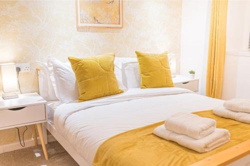 a bedroom with a large bed with yellow pillows at 4 BR Holiday Home Steps from Keswick Town Centre in Keswick