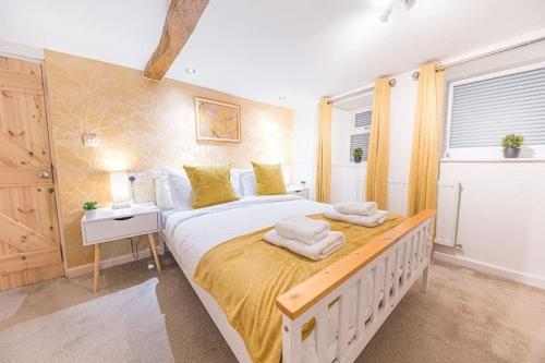 a bedroom with a large bed with towels on it at 4 BR Holiday Home Steps from Keswick Town Centre in Keswick