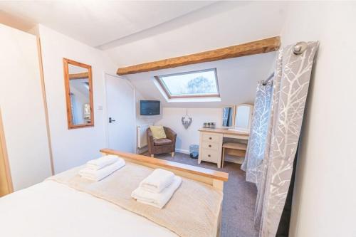 a bedroom with a bed and a desk and a window at 4 BR Holiday Home Steps from Keswick Town Centre in Keswick