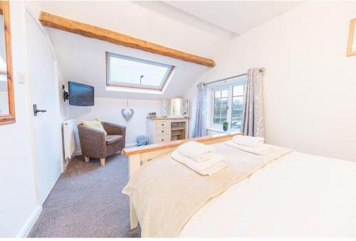 a bedroom with a bed and a chair and a window at 4 BR Holiday Home Steps from Keswick Town Centre in Keswick