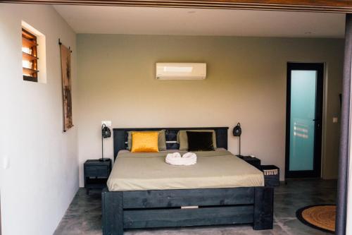 a bedroom with a large bed with yellow pillows at Naturescape Villa Cozy - Sint Michiel in Sint Michiel