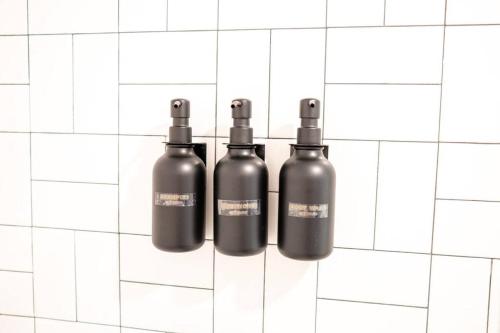 a group of three black bottles on a white tiled wall at King Bed, Parking, Near Stadium in Cincinnati