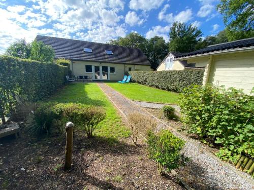 a backyard of a house with a yard with a fence at Le Bungalow 51 in Froid-Chapelle