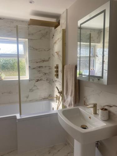 a white bathroom with a tub and a sink at Rivendell spacious two bedroom 1st floor flat in Kent