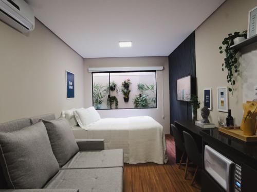 a living room with a bed and a couch at Apê Paulista Augusta in São Paulo