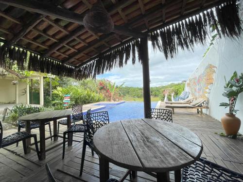 a patio with tables and chairs and a view of the water at Trancoso Villa Nobre in Trancoso