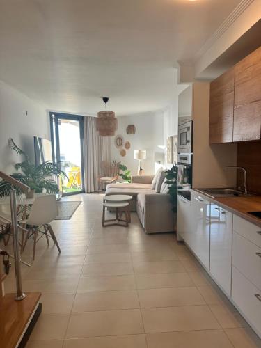 a kitchen and a living room with a couch at Apartamento Villa Bruno con vistas al mar, primera línea de playa in Cotillo