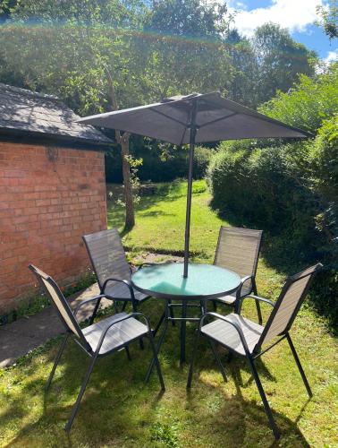 a table and chairs with an umbrella in the yard at Augusta lodge Moseley in Birmingham