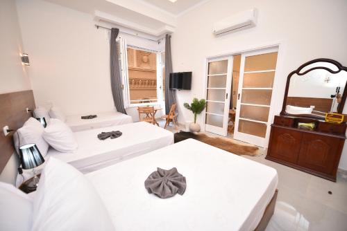 a bedroom with two beds and a mirror at family suites cairo downtown in Cairo