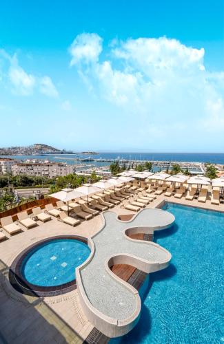 a resort with a pool and chairs and the ocean at Elite World Kuşadası in Kusadası