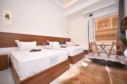two beds in a room with a table and chairs at family suites cairo downtown in Cairo