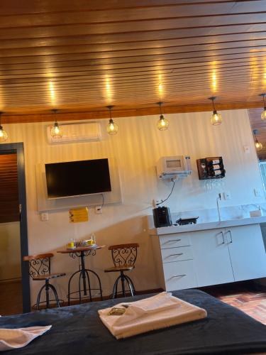 a room with a kitchen with a counter and a table at Lofts do Pilar - pousada in Ouro Preto