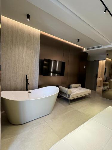 a large bathroom with a bath tub and a bed at Hotel Miramare in Vlorë