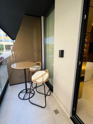 a table and two chairs in a room with a window at Hotel Miramare in Vlorë