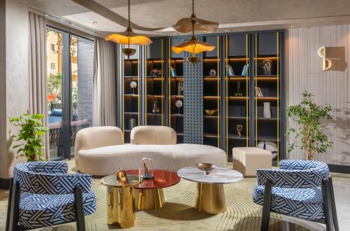 a living room with a couch and two tables and chairs at Elite World Kuşadası in Kusadası