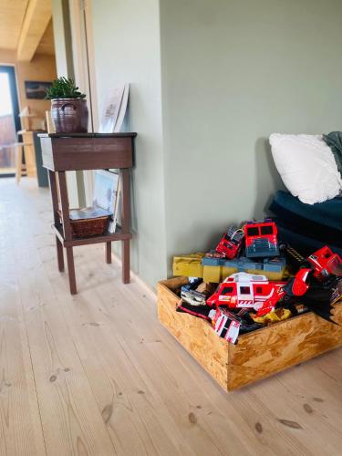 a wooden box with toy cars on it next to a table at Beautiful cottage with Mountain View in Fludir