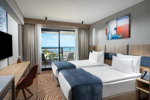 a hotel room with two beds and a television at Elite World Kuşadası in Kusadası