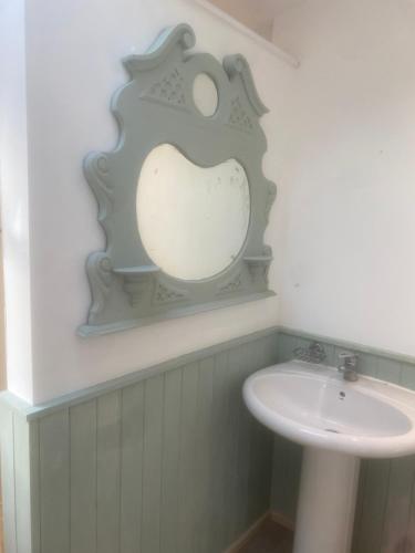 a bathroom with a sink and a mirror on the wall at Avalon cottage in Glastonbury