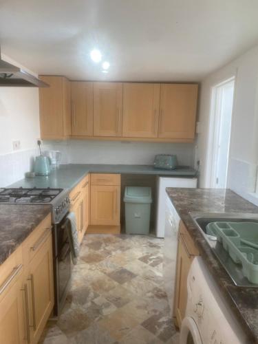 a kitchen with wooden cabinets and a stove top oven at Avalon cottage in Glastonbury