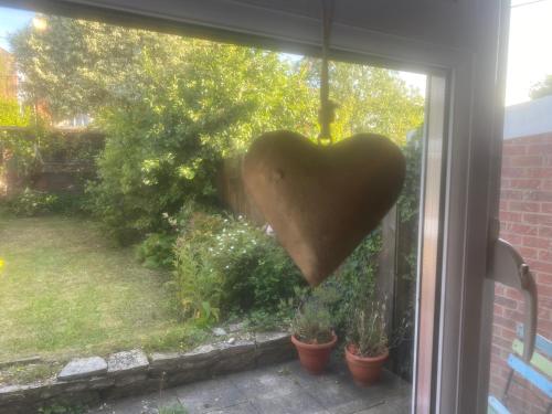 a heart hanging from a window with plants at Avalon cottage in Glastonbury