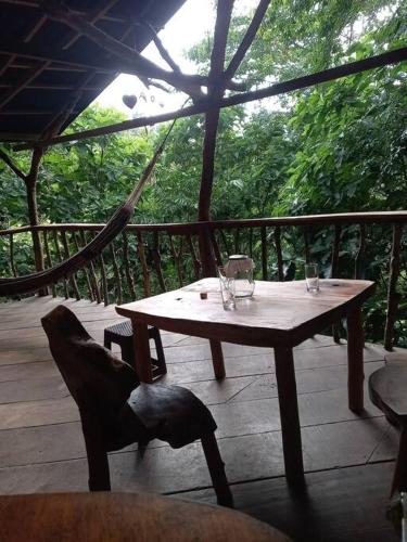a wooden table with two glasses on a porch at Casa del musgo y helecho in Minca