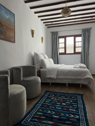 a bedroom with a bed and a couch and a chair at Riad Safia in Rabat