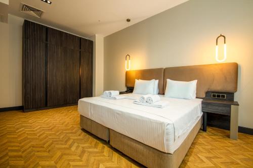 a bedroom with a large bed with two towels on it at V Center Hotel in Trabzon