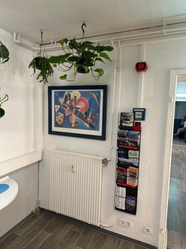 a room with a picture on a wall with a shelf at Pauli Hostel in Hamburg