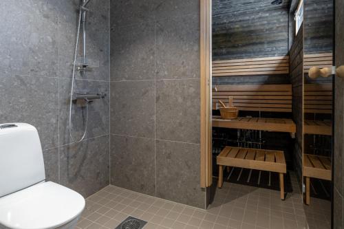 a bathroom with a shower and a toilet at Villa Kuusi by HiYlläs in Äkäslompolo