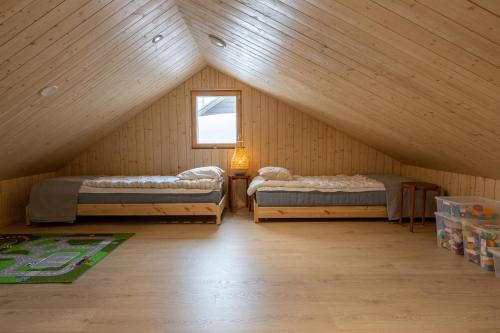 a attic room with two beds and a window at Villa Kuusi by HiYlläs in Äkäslompolo