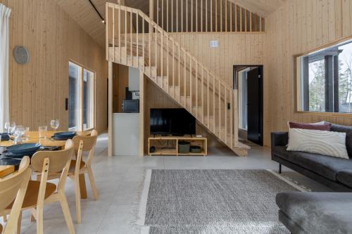 a living room with a staircase and a table and chairs at Villa Kuusi by HiYlläs in Äkäslompolo