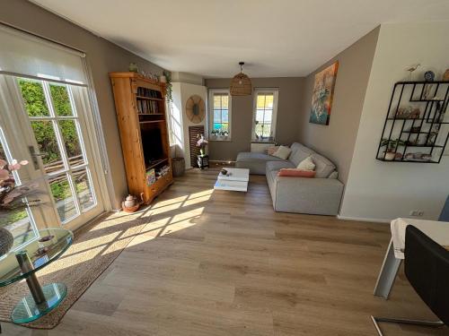 a living room with a couch and a table at Comfortabel en gezellig vakantiehuis bij het strand in Wemeldinge