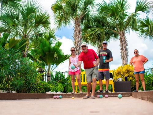 a group of people standing on a beach with balls at Sugarloaf Key Hotel at KOA Resort in Summerland Key