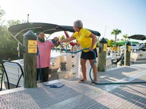 a man and a woman standing on a dock with a hose at Sugarloaf Key Hotel at KOA Resort in Summerland Key